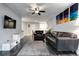 Open-concept living room with stylish gray floors, comfortable leather furniture, and modern art at 3807 Atrium Dr, Orlando, FL 32822