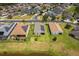 Aerial view of homes with solar panels, lush landscaping, and a pond at 4469 Biscayne Breeze Way, Kissimmee, FL 34744