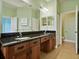 Bathroom with dual sinks, granite countertops, and a large mirror at 4469 Biscayne Breeze Way, Kissimmee, FL 34744