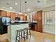 Well-equipped kitchen with wood cabinets, black appliances, and a breakfast bar for seating at 4469 Biscayne Breeze Way, Kissimmee, FL 34744