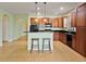 Spacious kitchen featuring a breakfast bar, wood cabinets, tile floor, and modern appliances at 4469 Biscayne Breeze Way, Kissimmee, FL 34744