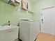 Laundry room featuring a sink, washer, dryer, storage shelf, and tile flooring at 4469 Biscayne Breeze Way, Kissimmee, FL 34744