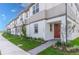 Townhome exterior with red door, green lawn, and tasteful landscaping at 4830 Prairie Preserve Run, St Cloud, FL 34772
