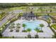 Aerial view of community pool area, featuring a covered pavilion, palm trees, and a playground at 4830 Prairie Preserve Run, St Cloud, FL 34772
