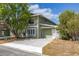 Charming two-story home with green siding, a concrete driveway, and mature trees in the front yard at 522 Boxelder Ave, Altamonte Springs, FL 32714