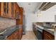 Galley-style kitchen with wood cabinetry, stainless steel appliances, and decorative tile backsplash at 522 Boxelder Ave, Altamonte Springs, FL 32714
