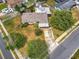 Aerial shot of the property showing a driveway, mature tree, and landscape in a quiet residential neighborhood at 5811 Harcourt Ave, Orlando, FL 32839
