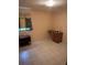 Modest bedroom with tiled flooring, small desk, and shelf, ideal for a simple and functional space at 5811 Harcourt Ave, Orlando, FL 32839