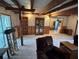 Spacious living room featuring exposed beam ceiling, a ceiling fan, and a view to the kitchen at 5811 Harcourt Ave, Orlando, FL 32839
