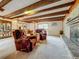 Open living area with exposed beams, a brick fireplace, and comfortable seating at 5811 Harcourt Ave, Orlando, FL 32839
