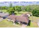 An aerial view of the home shows a large yard, outbuildings, and mature trees at 604 S Oxalis Ave, Orlando, FL 32807