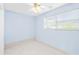 A bright bedroom offers a ceiling fan, a window, tile flooring, and light blue paint at 604 S Oxalis Ave, Orlando, FL 32807
