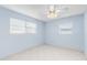 A simple bedroom features tile floors, natural light, a fan, and pale blue paint at 604 S Oxalis Ave, Orlando, FL 32807