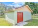 A detached out-building with a metal roof, concrete floors, and a red door at 604 S Oxalis Ave, Orlando, FL 32807