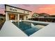 Backyard featuring a sleek pool and patio, complemented by mature landscaping under a colorful sky at 675 Primrose Willow Way, Apopka, FL 32712