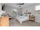 Well-lit bedroom featuring a ceiling fan, a bed, and a comfortable chair in front of the window at 675 Primrose Willow Way, Apopka, FL 32712