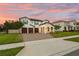 Beautiful two-story home with a three-car garage, arched entryway, and manicured front lawn at 675 Primrose Willow Way, Apopka, FL 32712