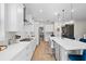 Bright, open kitchen boasts white cabinets, quartz countertops, and stainless steel appliances at 675 Primrose Willow Way, Apopka, FL 32712