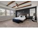 Main bedroom featuring wood ceiling beams, a blue accent wall and a large bed with side tables at 675 Primrose Willow Way, Apopka, FL 32712