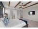 Main bedroom with ceiling beams, accent wall, and open doorways to the hallway and bathroom at 675 Primrose Willow Way, Apopka, FL 32712