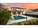 Backyard features a modern pool, covered patio, and lush landscaping, ideal for relaxation and entertaining at 675 Primrose Willow Way, Apopka, FL 32712