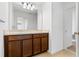 Bathroom with dual sinks, dark cabinets, and large mirror with decorative lighting above at 683 Campo Ln, Davenport, FL 33837