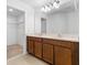 Bathroom with a double sink vanity, dark wood cabinets, large mirror and walk-in closet at 683 Campo Ln, Davenport, FL 33837
