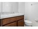 Cozy bathroom features a wooden vanity with sink, white countertop, toilet and wall mirror at 683 Campo Ln, Davenport, FL 33837