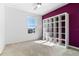 Bedroom with a window, ceiling fan, and purple accent wall with a cube organizer at 683 Campo Ln, Davenport, FL 33837