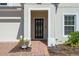 The front entrance showcases a modern door framed by white pillars and red brick walkway at 683 Campo Ln, Davenport, FL 33837