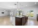 Kitchen island with granite countertops and dark wood cabinets, connecting to a spacious living room at 683 Campo Ln, Davenport, FL 33837