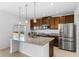 Bright, modern kitchen with granite countertops, stainless steel appliances, and a large island at 683 Campo Ln, Davenport, FL 33837