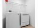 Laundry room showcasing a washer, dryer, overhead shelving, and tile flooring at 683 Campo Ln, Davenport, FL 33837