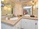 Bathroom featuring neutral toned tile counter and double vanity with mirrors and cabinets at 736 Guy Rd, Orlando, FL 32828