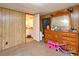Bedroom featuring wood paneled walls, neutral carpeting, and doorway to ensuite bathroom at 736 Guy Rd, Orlando, FL 32828