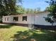 Exterior of home with white siding and dark trim, landscaping, and a yard at 736 Guy Rd, Orlando, FL 32828