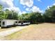 Single-story home featuring a long driveway and a large, tree-filled lot at 736 Guy Rd, Orlando, FL 32828