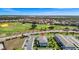 An aerial view of a blue and yellow townhome community adjacent to a lush golf course at 743 Driving Range Ct, Reunion, FL 34747