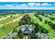 Aerial view showcases a community clubhouse with a pool, tennis courts, and golf course at 743 Driving Range Ct, Reunion, FL 34747
