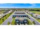 Aerial view of a neighborhood featuring blue townhomes with ample parking and lush landscaping at 743 Driving Range Ct, Reunion, FL 34747