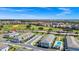 Aerial view shows townhomes with a nearby community pool and golf course in the distance at 743 Driving Range Ct, Reunion, FL 34747
