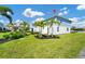 Blue and white two story townhome features a manicured lawn with mature palm trees and lush green grass at 743 Driving Range Ct, Reunion, FL 34747