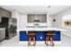 Bright kitchen with gray cabinets, island with seating, and modern stainless steel appliances at 743 Driving Range Ct, Reunion, FL 34747