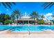 Large pool with inviting blue water surrounded by palm trees and ample seating at 743 Driving Range Ct, Reunion, FL 34747