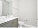 A clean powder room features a modern vanity and toilet, perfect for guests at 743 Driving Range Ct, Reunion, FL 34747