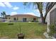 Backyard featuring a pool, a white fence, green grass and landscaping, patio doors, and a fire pit at 854 Mendoza Dr, Kissimmee, FL 34758