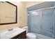 Bathroom featuring a vanity, mirror, toilet, and bathtub-shower combo with blue tiling and a sliding glass door at 854 Mendoza Dr, Kissimmee, FL 34758
