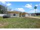 Side view of a tan house with arched windows and a brick paver driveway leading to a two-car garage at 854 Mendoza Dr, Kissimmee, FL 34758