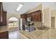 Eat-in kitchen featuring stainless steel appliances, dark wood cabinets, granite countertops, and mosaic tile backsplash at 854 Mendoza Dr, Kissimmee, FL 34758