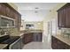 Eat-in kitchen with stainless steel appliances, dark wood cabinets, and granite countertops at 854 Mendoza Dr, Kissimmee, FL 34758